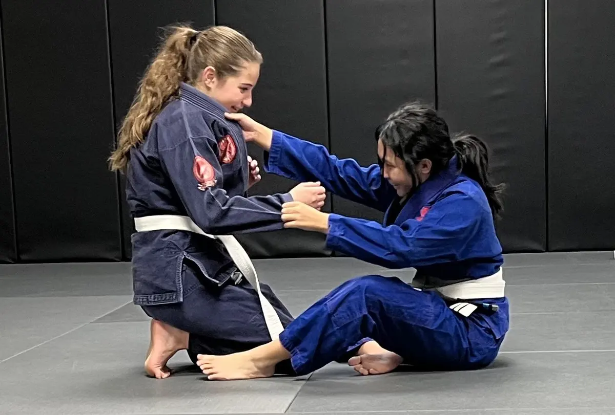 Two women drilling a seated guard position at Jiyu